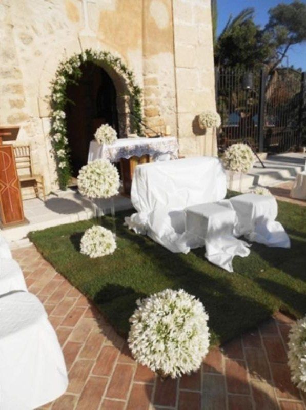 Altare per matrimoni all'aperto con addobbi floreali in bianco