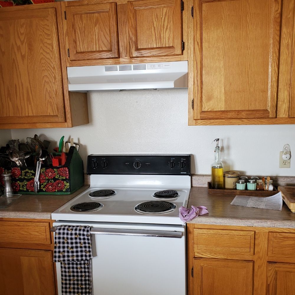 A kitchen with wooden cabinets and a stove top oven