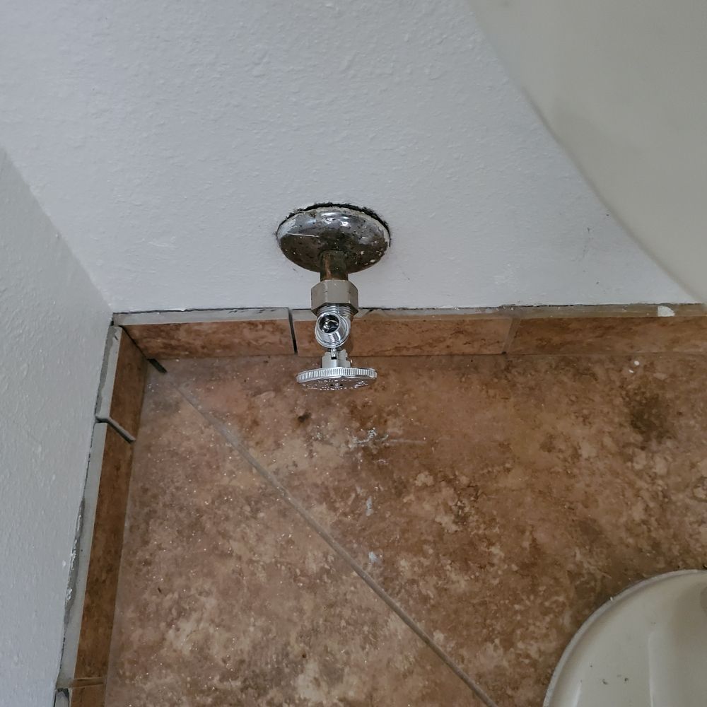 A bathroom with a toilet and a faucet on the floor