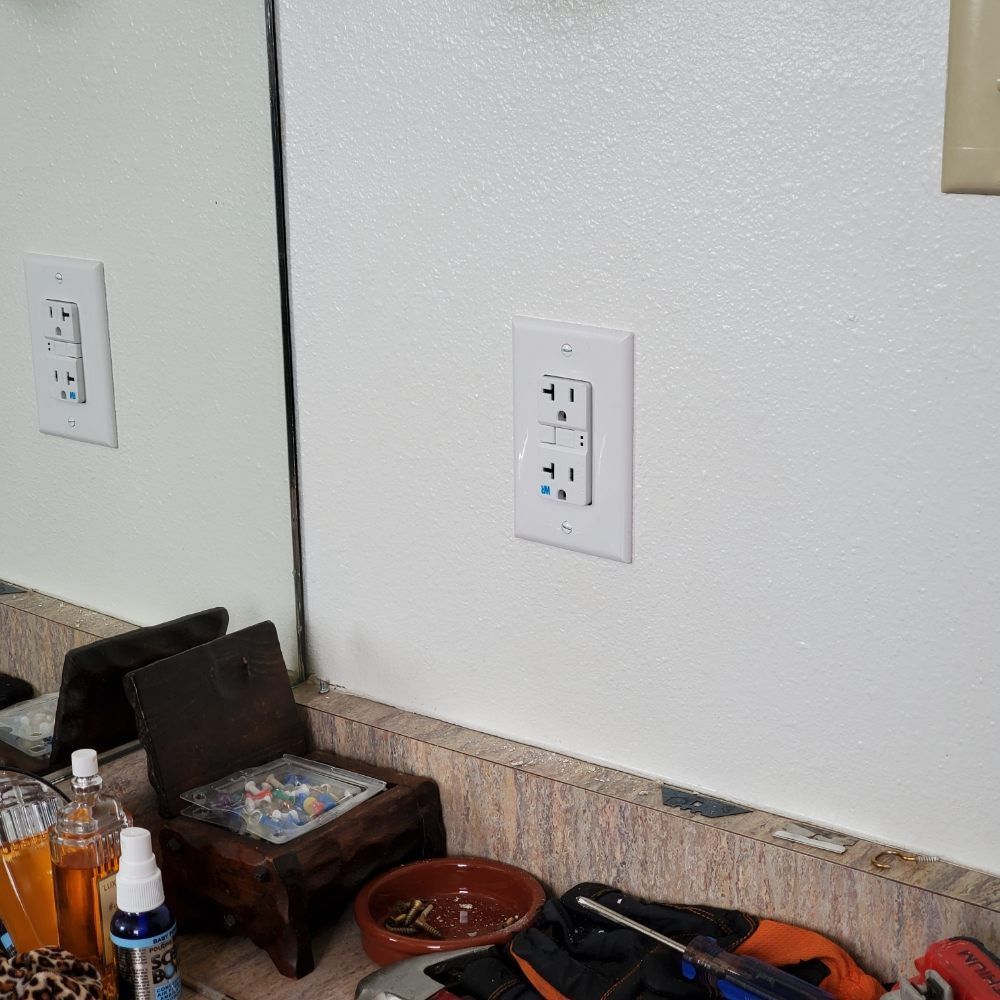 A bathroom with two electrical outlets and a mirror