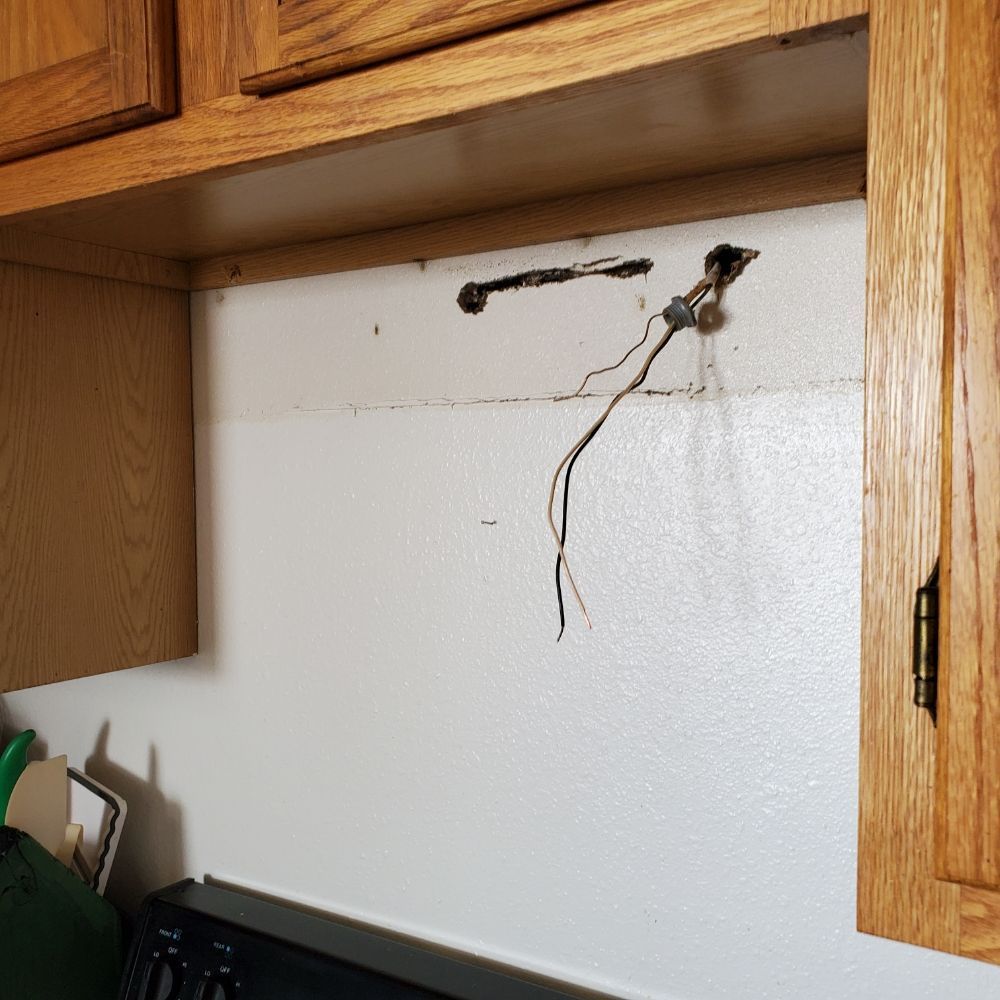 A kitchen with wooden cabinets and a black stove top oven