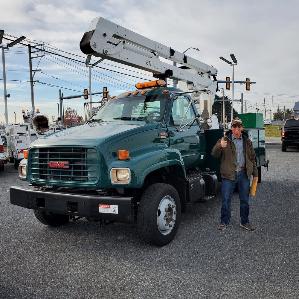 A man is standing in front of a green gmc truck