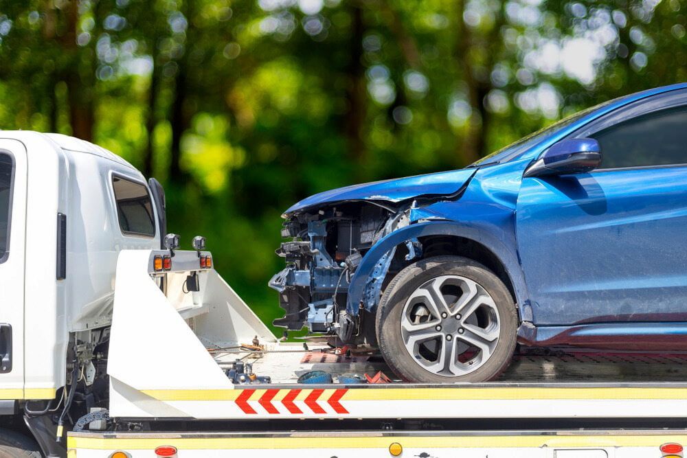 Blue Damaged Car on a Tow Truck, Exterior Damage Visible — Prompt Tilt Tray Towing & Recovery in Adelaide River, NT