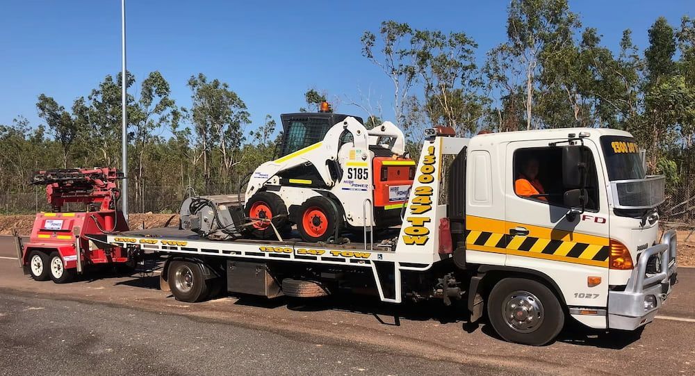 Tow Truck Transporting a White and Orange Bobcat Construction Vehicle — Prompt Tilt Tray Towing & Recovery in Herbert, NT