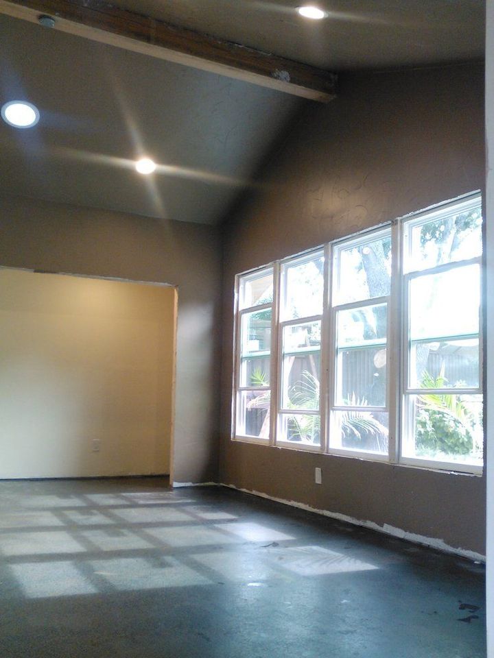 An empty room with lots of windows and a ceiling light