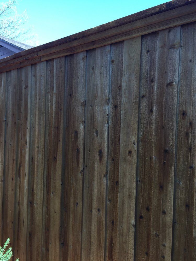 A wooden fence with a blue sky in the background