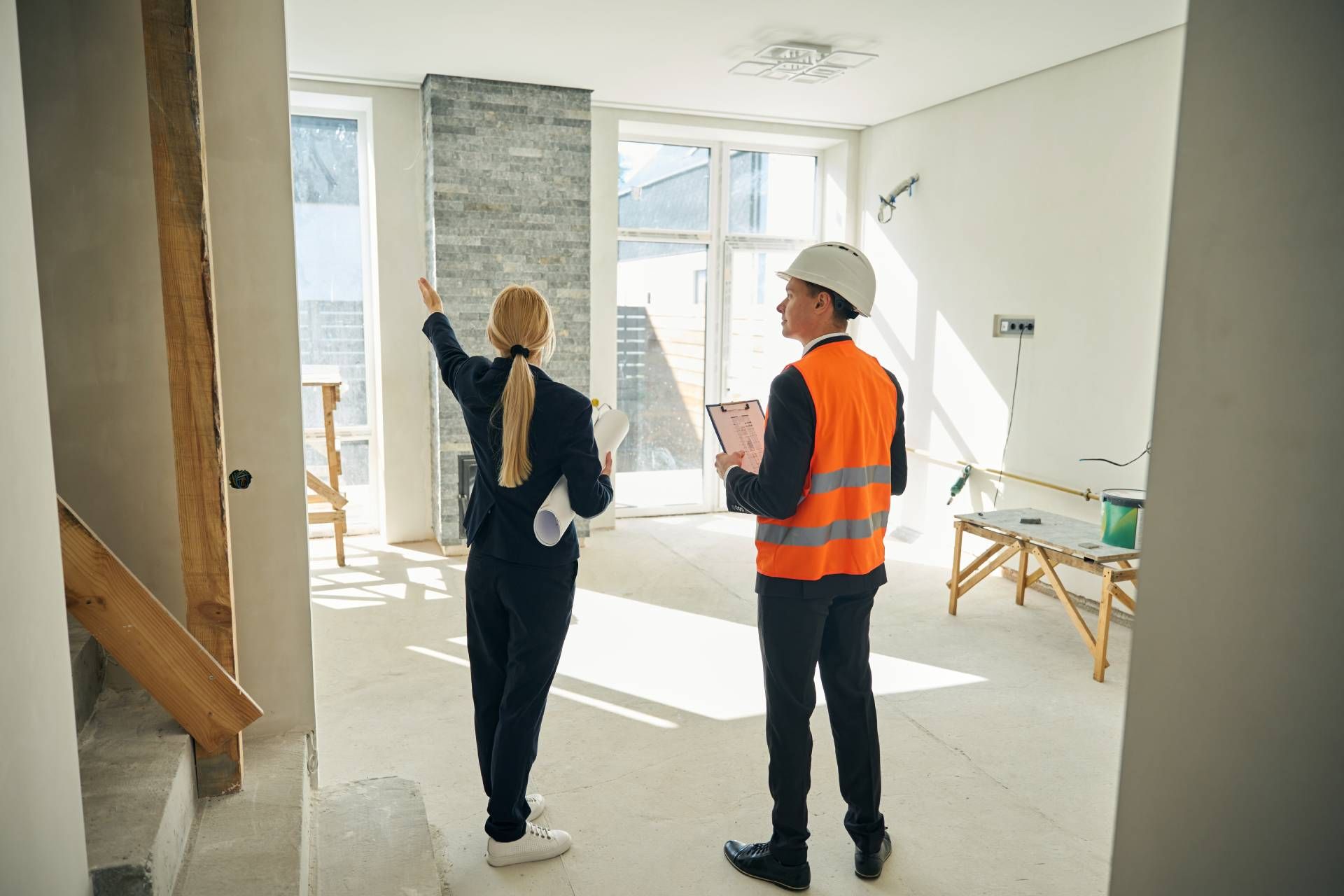 A man and a woman are looking at a house under construction.