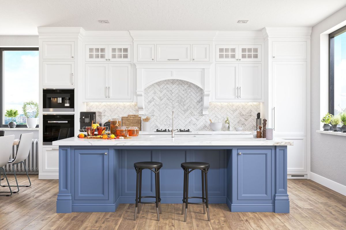 A kitchen with blue cabinets and white cabinets and a large island.