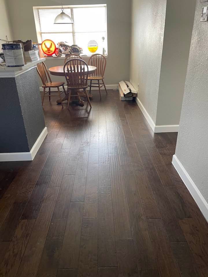 A dining room with hardwood floors and a table and chairs.