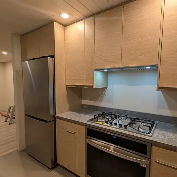 Modern kitchen with light wood cabinets, stainless steel appliances, and gas cooktop.