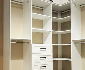 White closet with shelves, drawers, and hanging rods. The closet is empty.