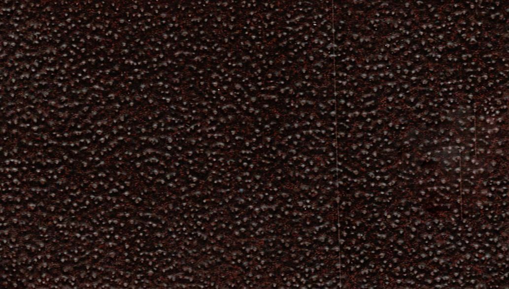 Dark brown textured surface with a repeating speckled pattern
