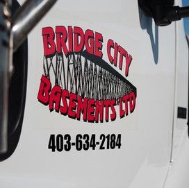 A bridge city basements ltd truck is parked on the side of the road.