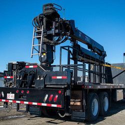 A large crane is attached to the back of a truck.