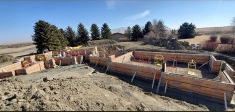 A house is being built on top of a dirt hill.