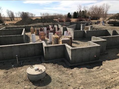 The foundation of a house is being built in the dirt.