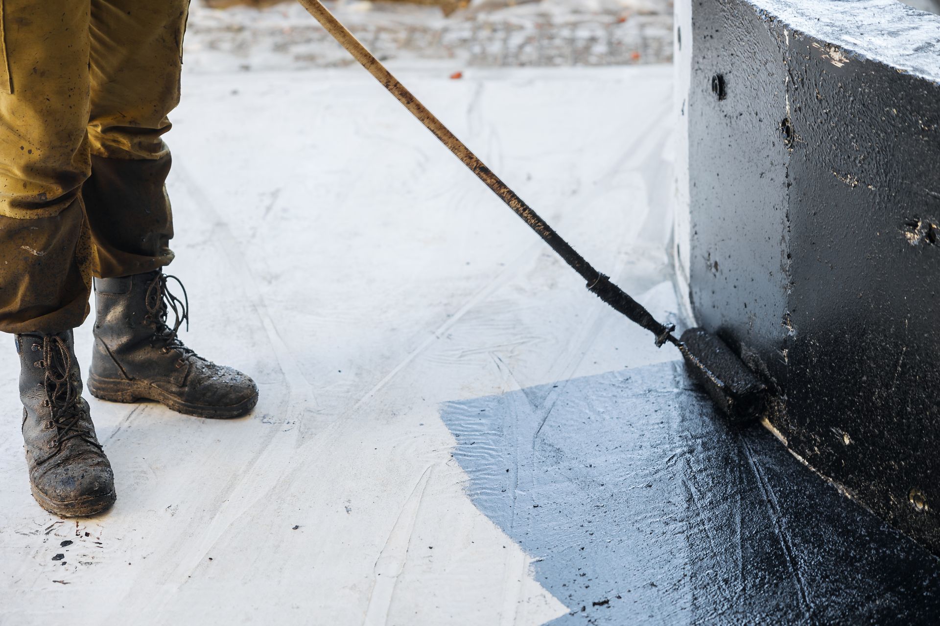 A man is painting a concrete block with a brush.