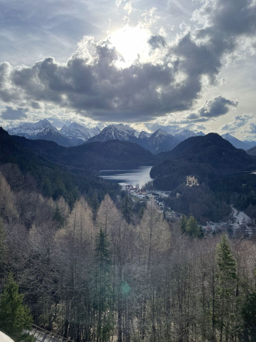 Sun obscured by clouds over mountains. 