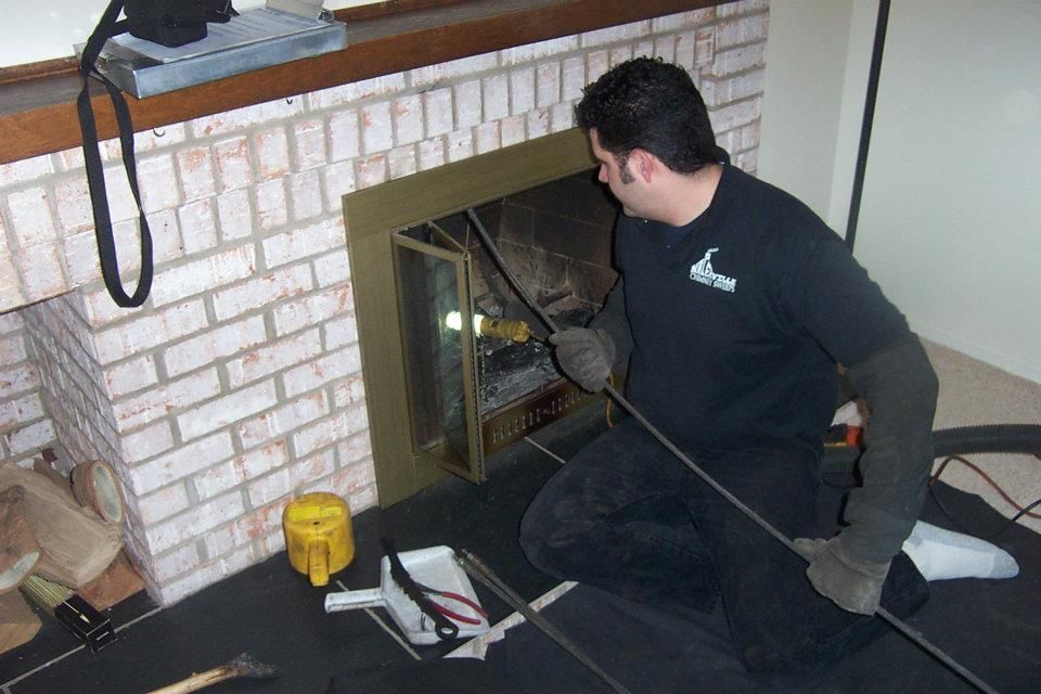 A man in a black shirt is working on a fireplace