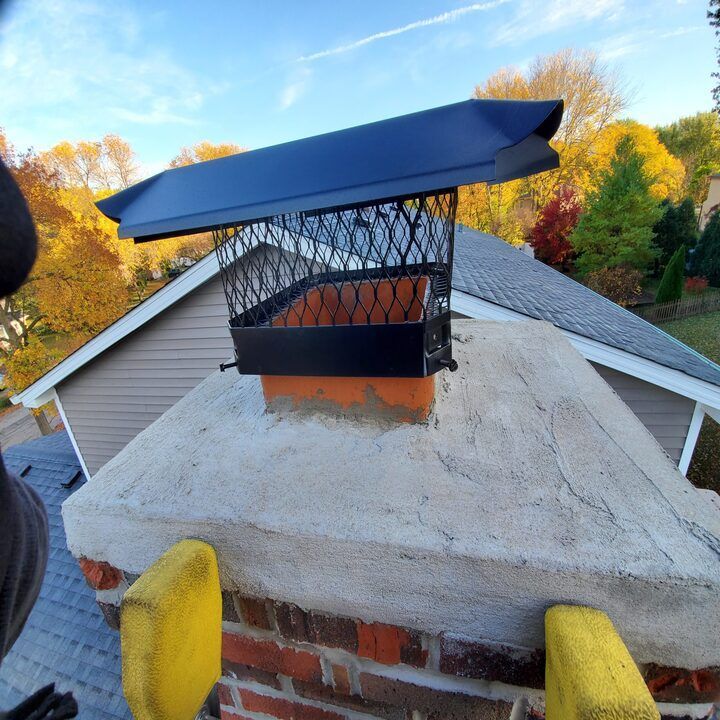 A brick chimney with a black chimney cap on top of it