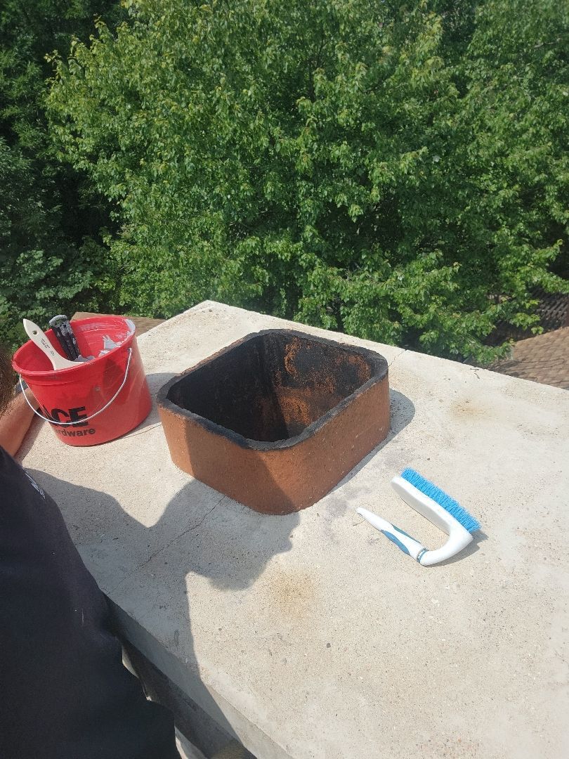 A bucket and a pot are sitting on a table.