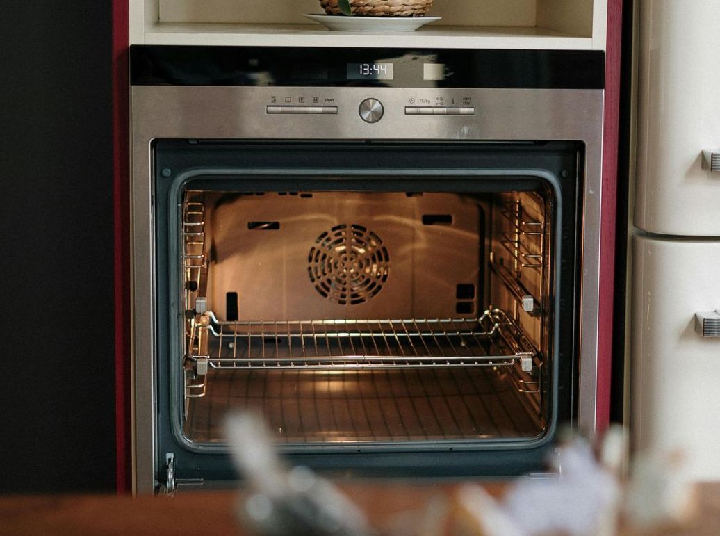 A close up of an oven with the door open in a kitchen.