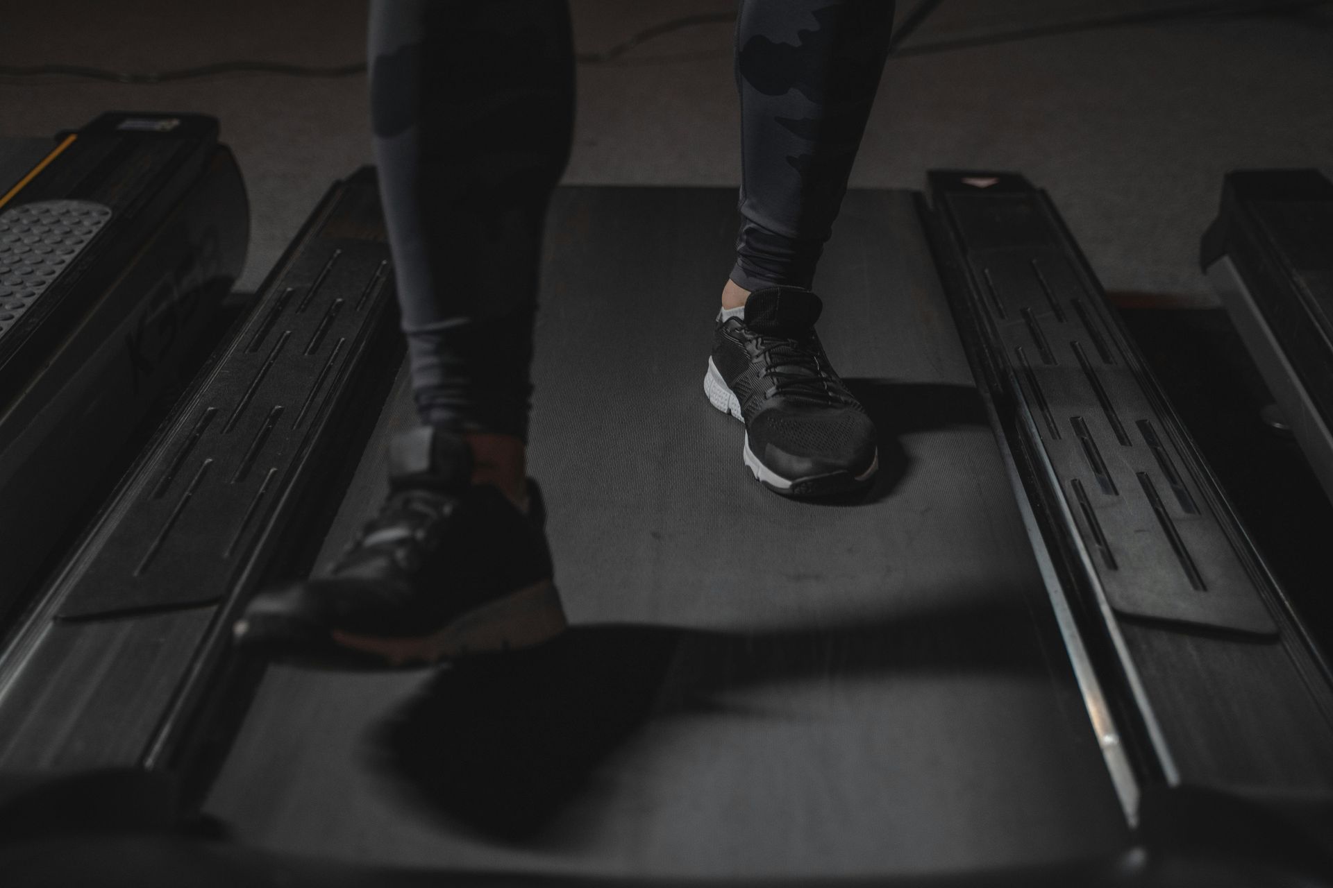 A person is walking on a treadmill in a gym.