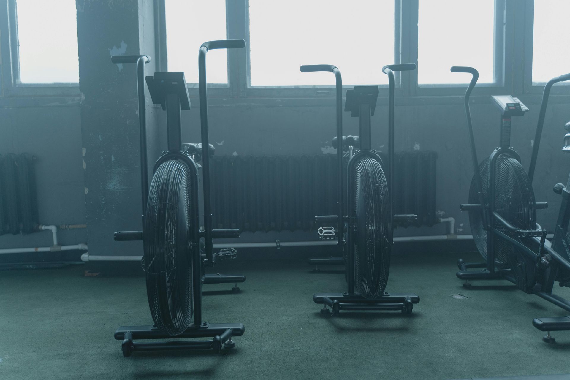 A row of exercise bikes are lined up in a gym.