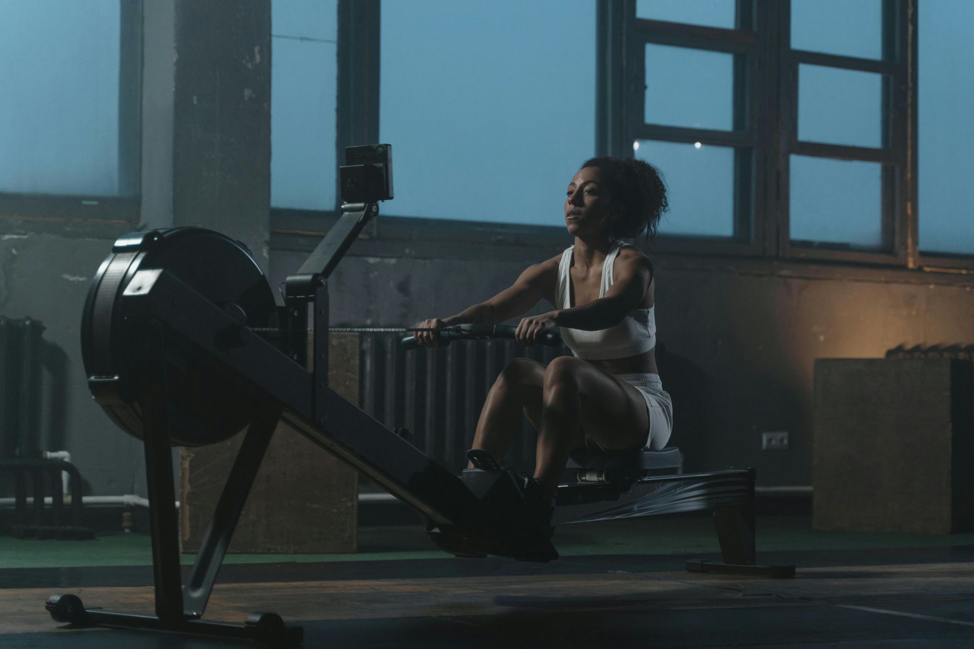 A woman is riding a rowing machine in a gym.