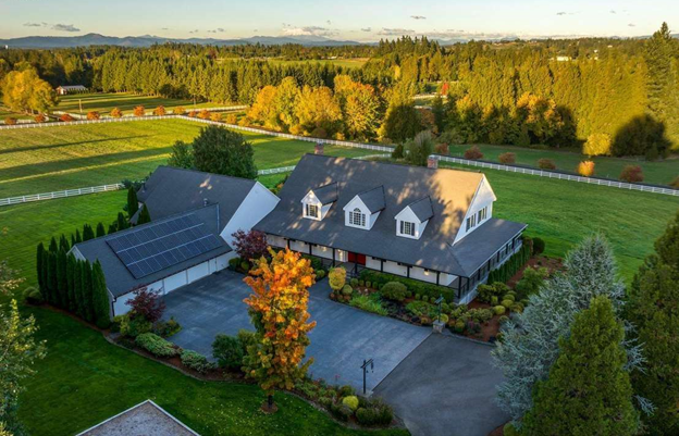 A large gray house with a white garage door and a porch.