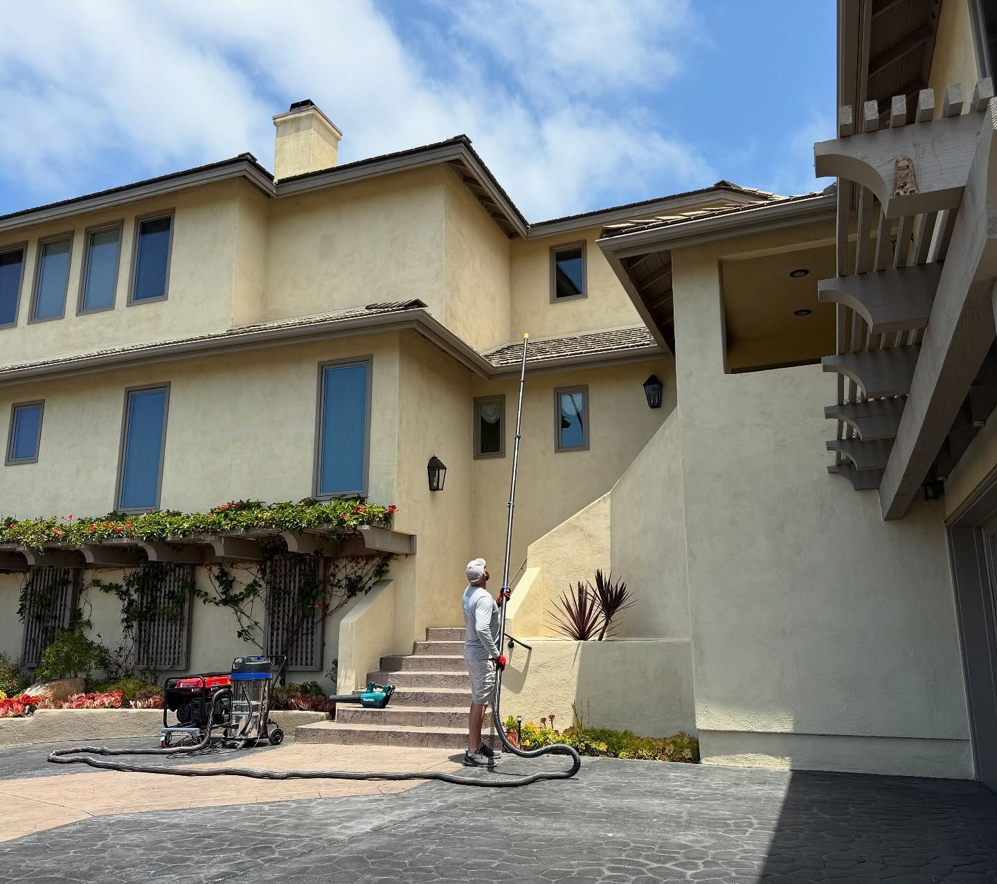 A man is standing in front of a large house