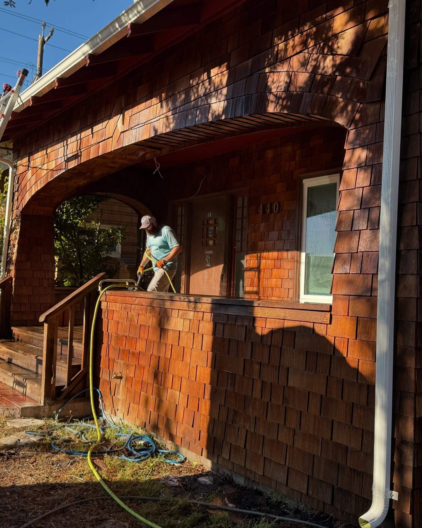 A man is standing on the porch of a brick house