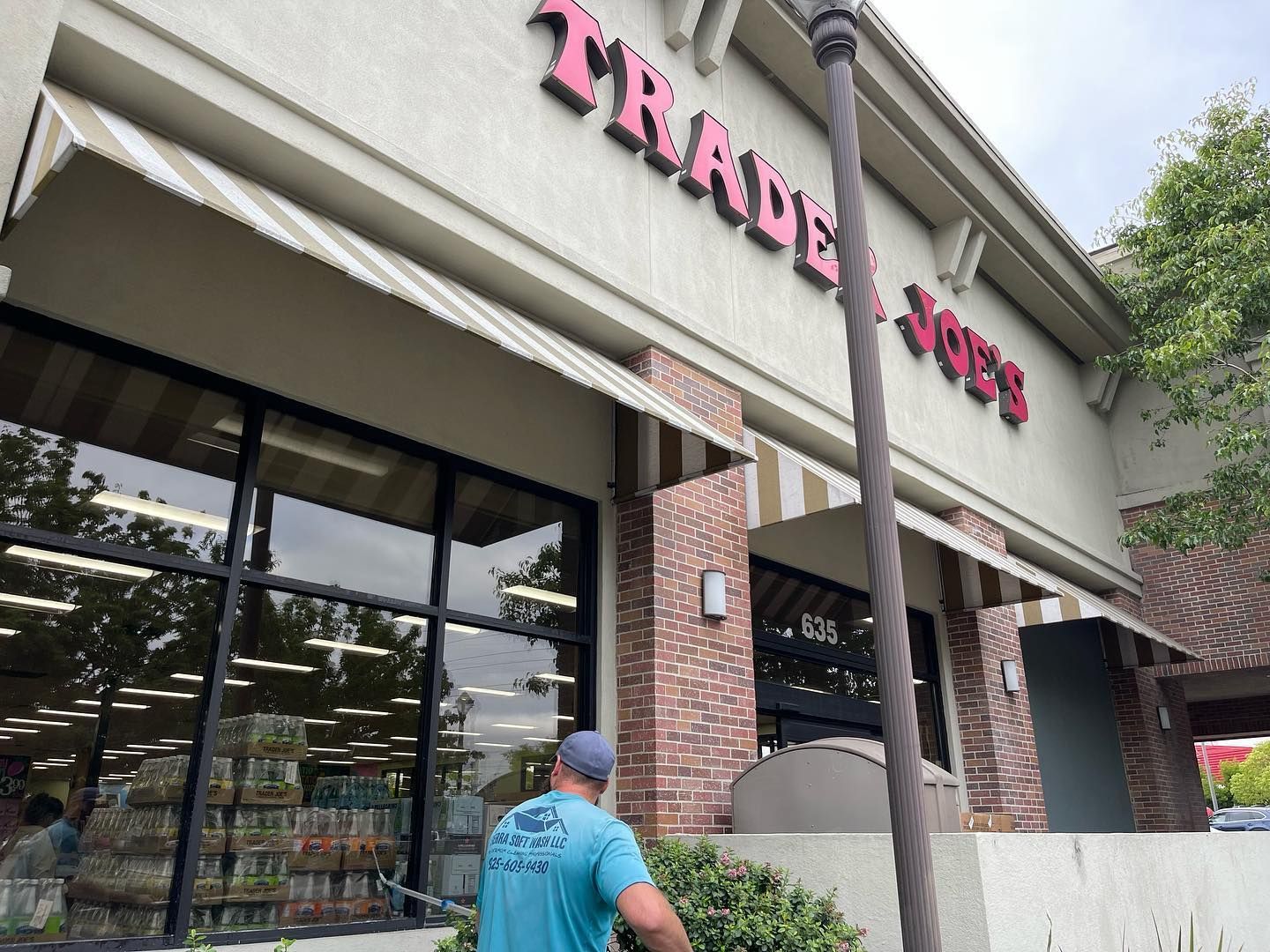 A man is standing in front of a trader joes store