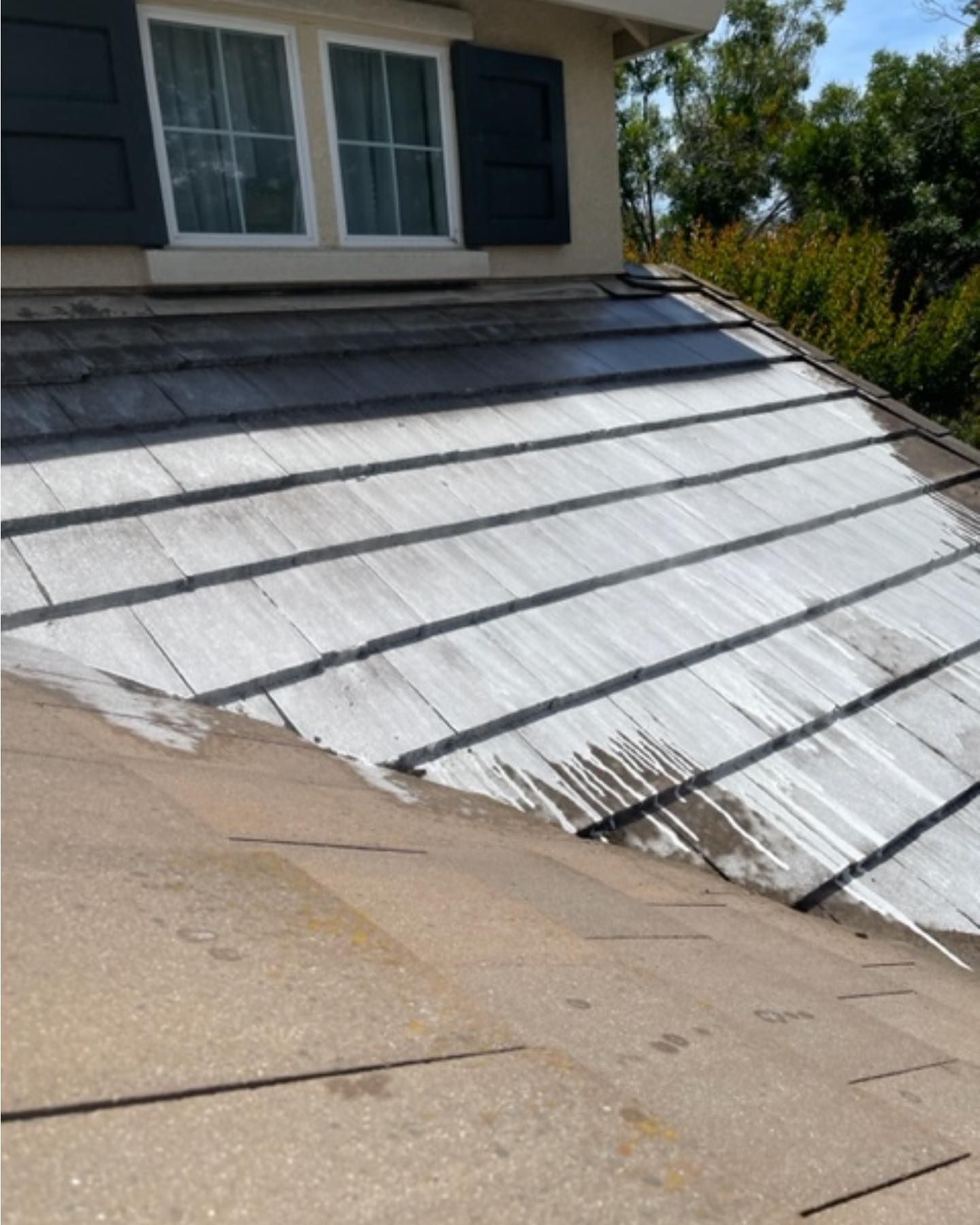 The roof of a house is being painted white