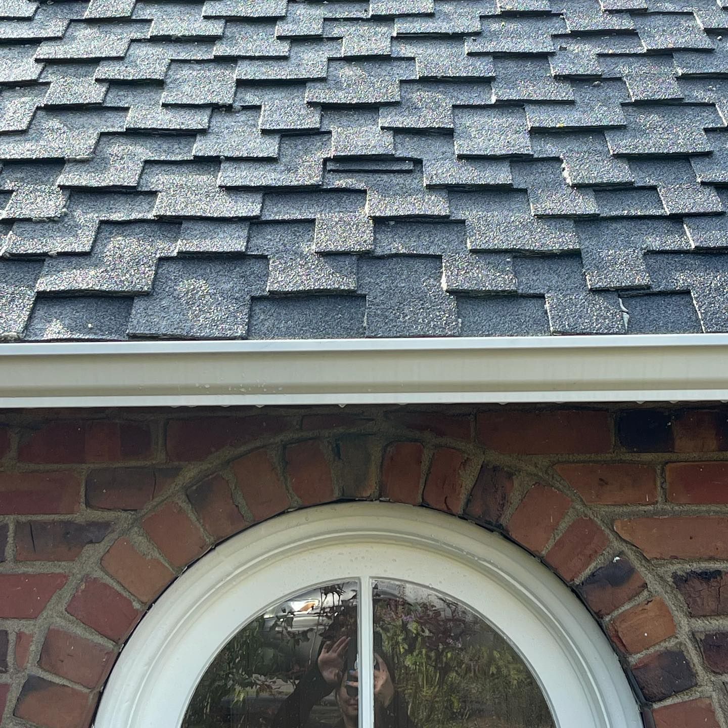 A brick building with a round window and a roof