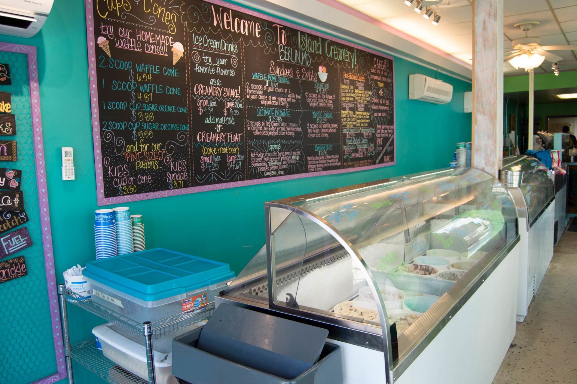 The inside of an ice cream shop with a menu on the wall