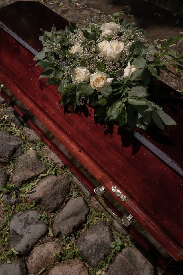 White flowers on top of a coffin for burial services in Laredo, TX