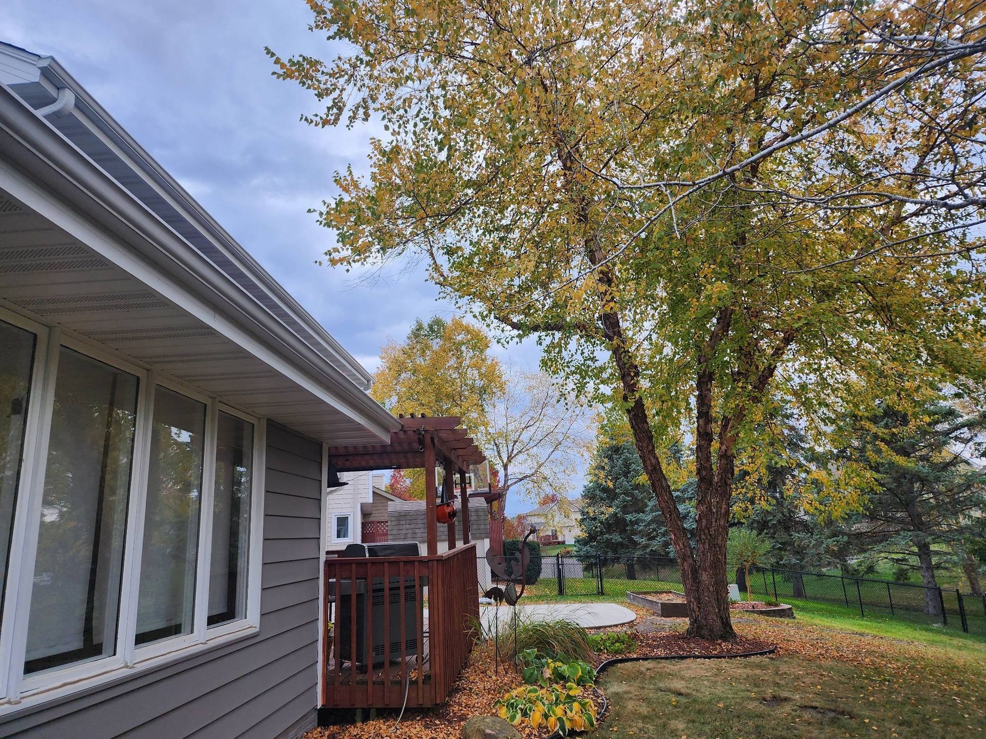 A house with a deck and trees in front of it.