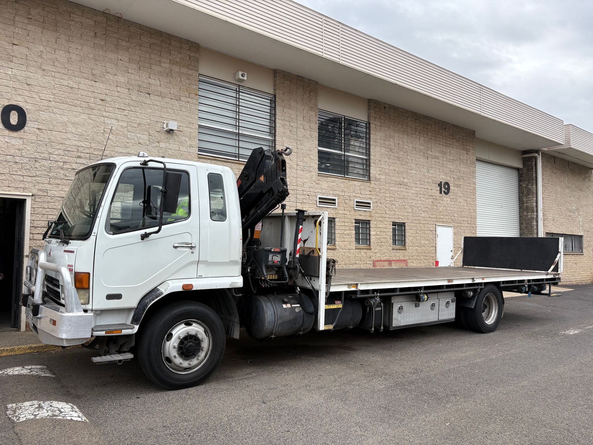 White flatbed truck with crane.