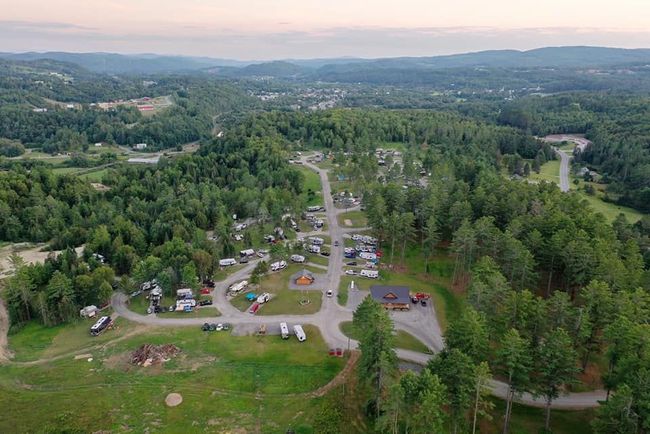An aerial view of Kingdom Campground surrounded by trees and mountains.