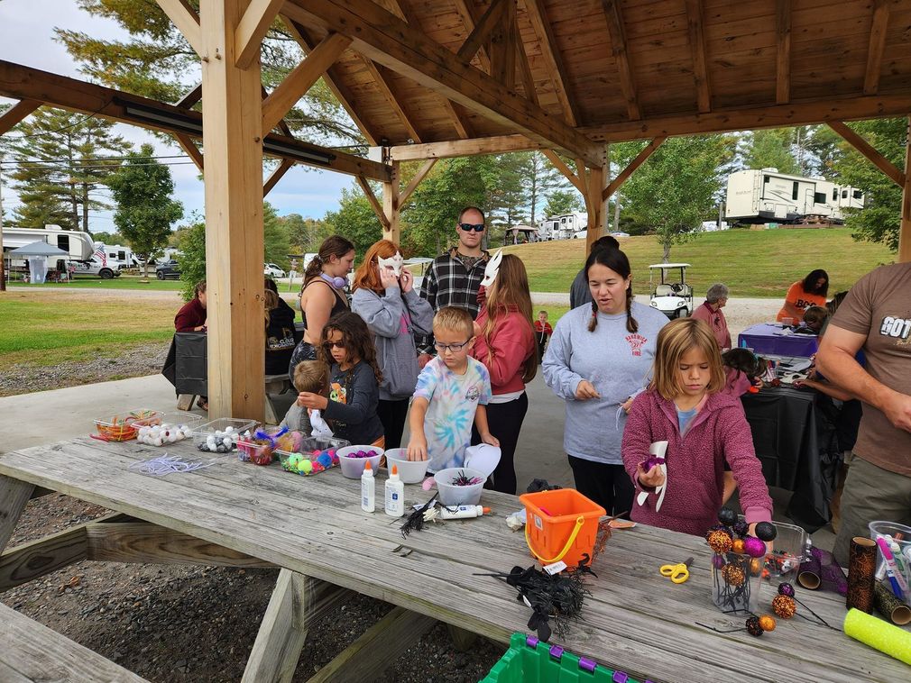 A group of people are sitting at a picnic table under a gazebo.