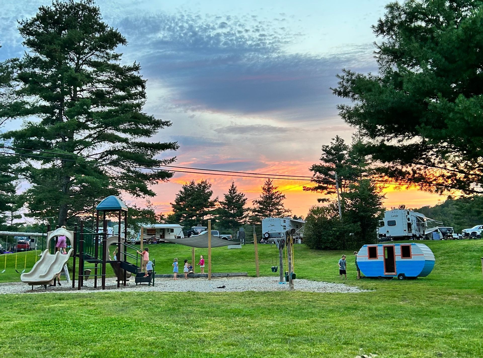 The playground in Kingdom Campground with a sunset in the background.