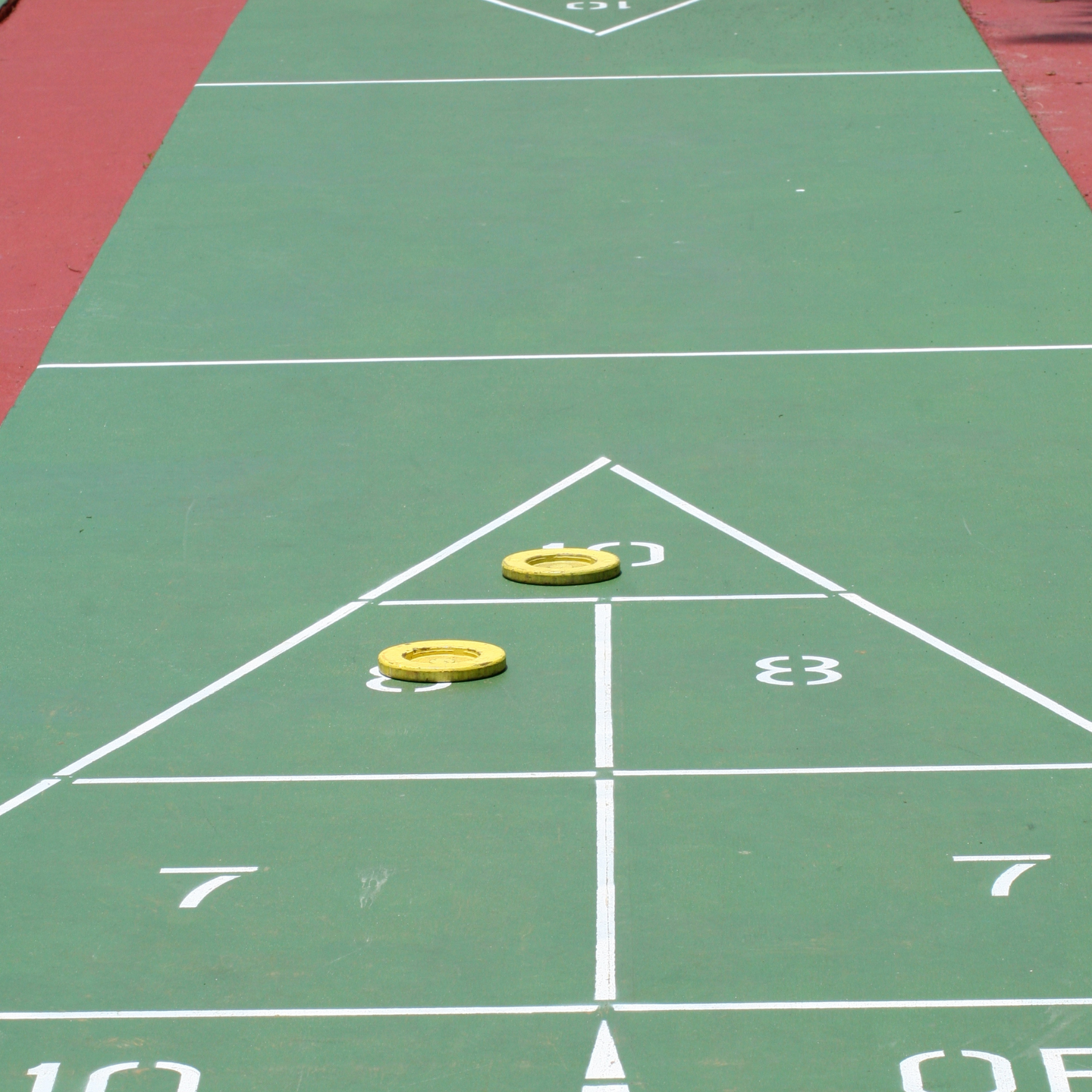 A green shuffleboard court with the number 7 on it
