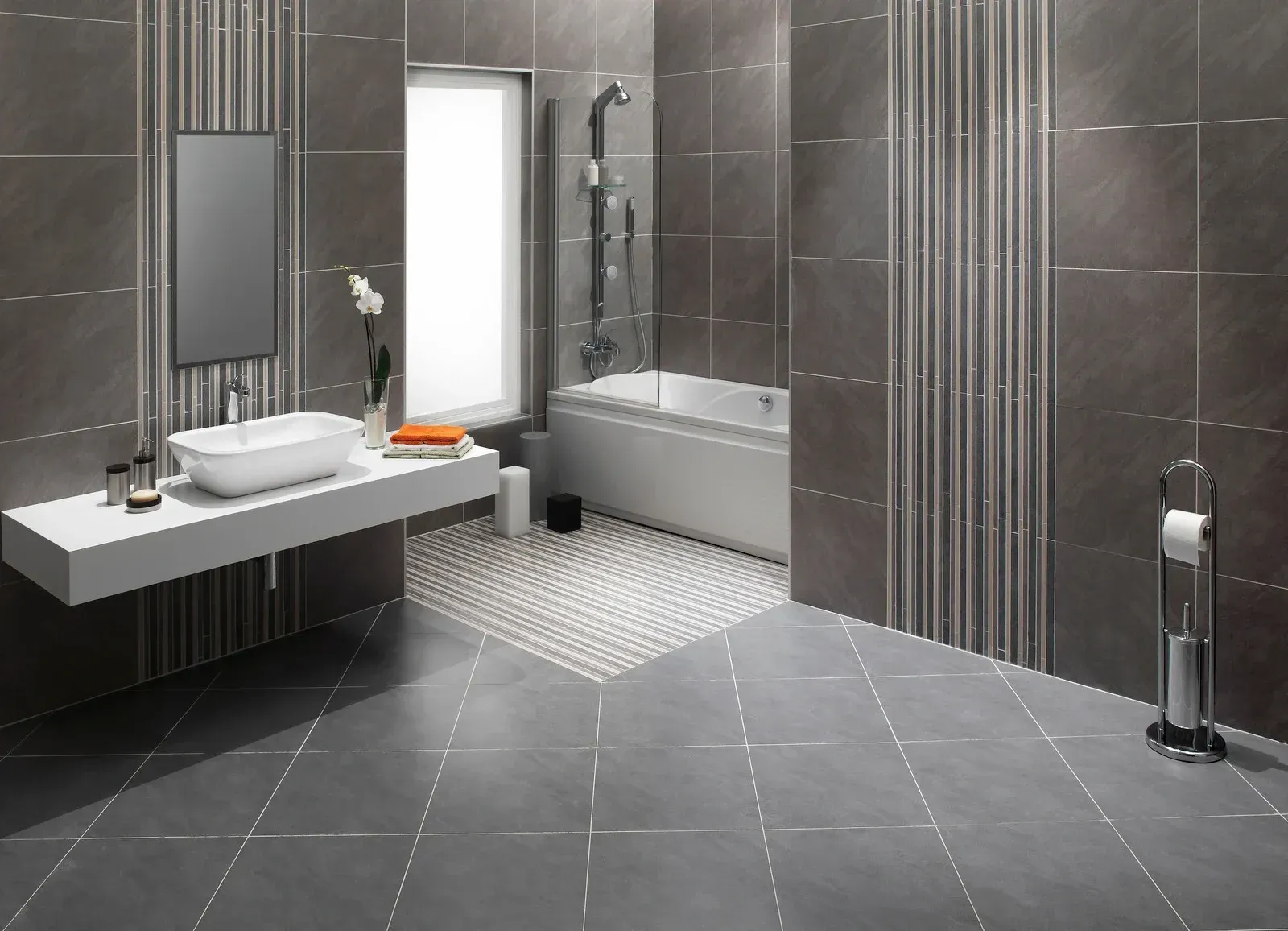 Modern gray bathroom with floating sink, bathtub, and patterned tile flooring.