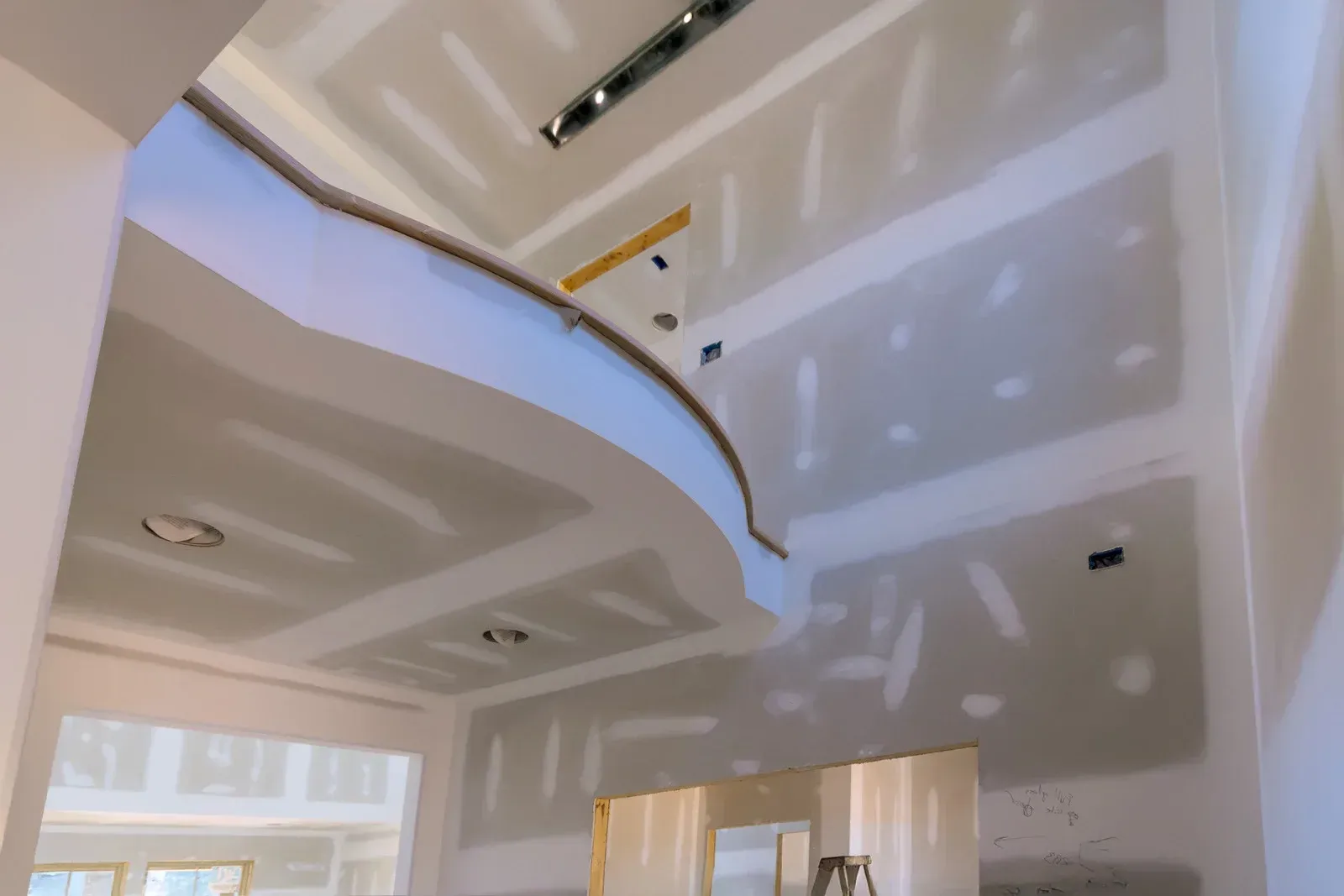Interior construction with drywall on walls and ceiling. Curved soffit detail.