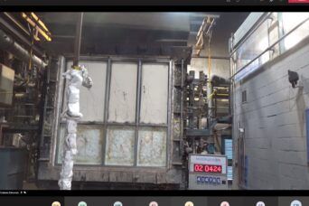 A test furnace with a large, rectangular door and a digital timer reading 02:04:24, positioned inside an industrial lab.