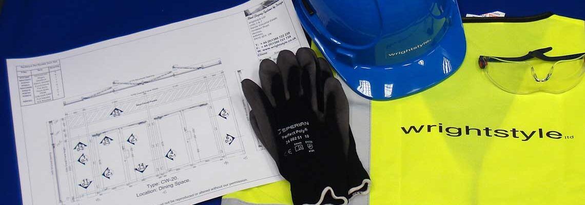 Construction site items including a blueprint, black work gloves, a blue hard hat, safety glasses, and a neon yellow vest.