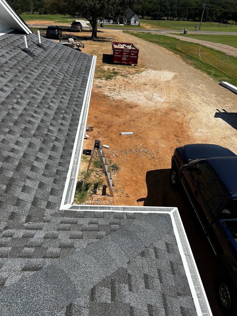 A car is parked on the side of a house next to a roof.