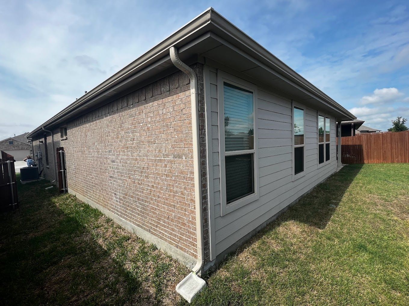 A house with a lot of windows and a gutter on the side of it.
