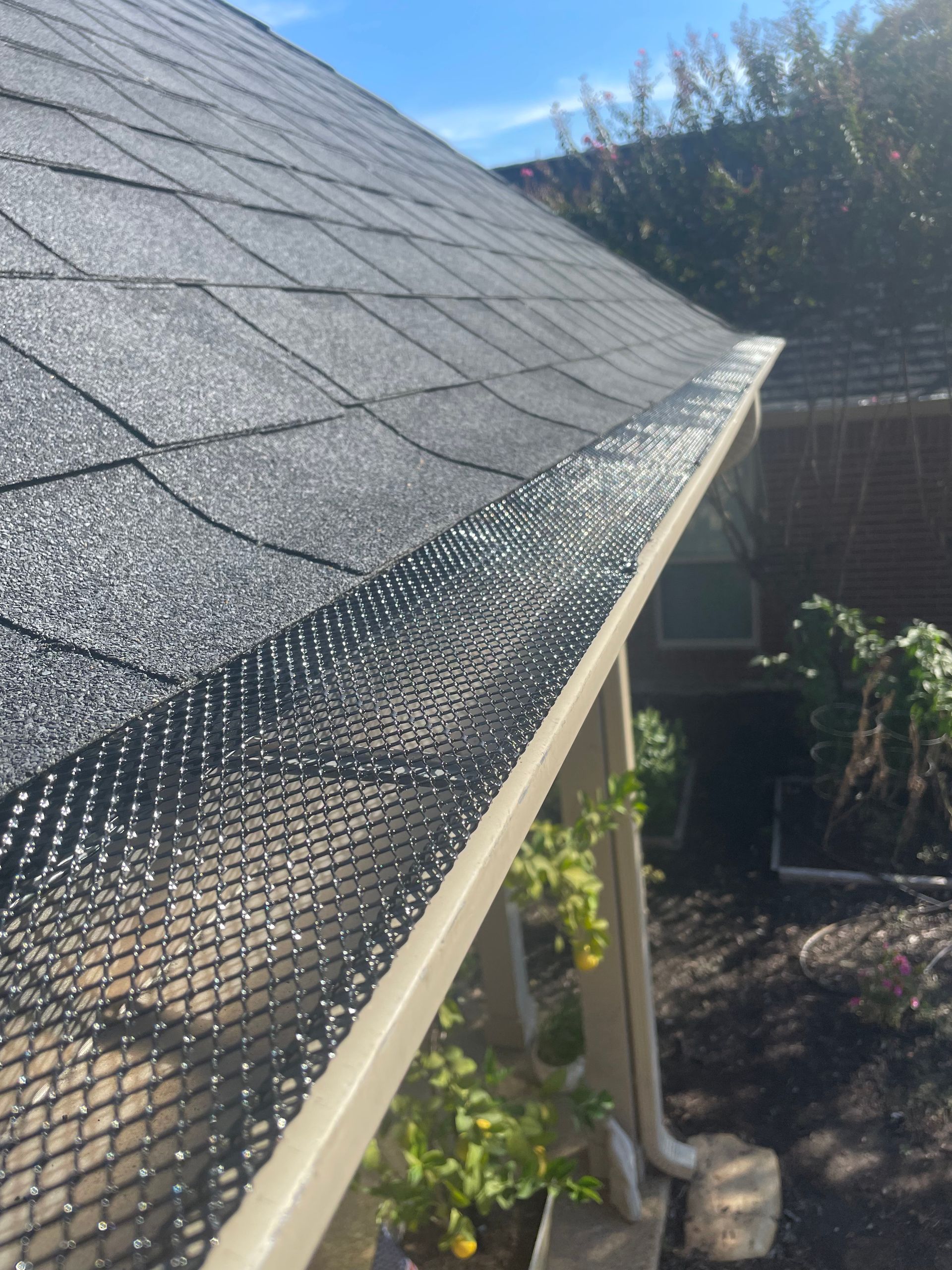 A gutter with a black mesh covering it